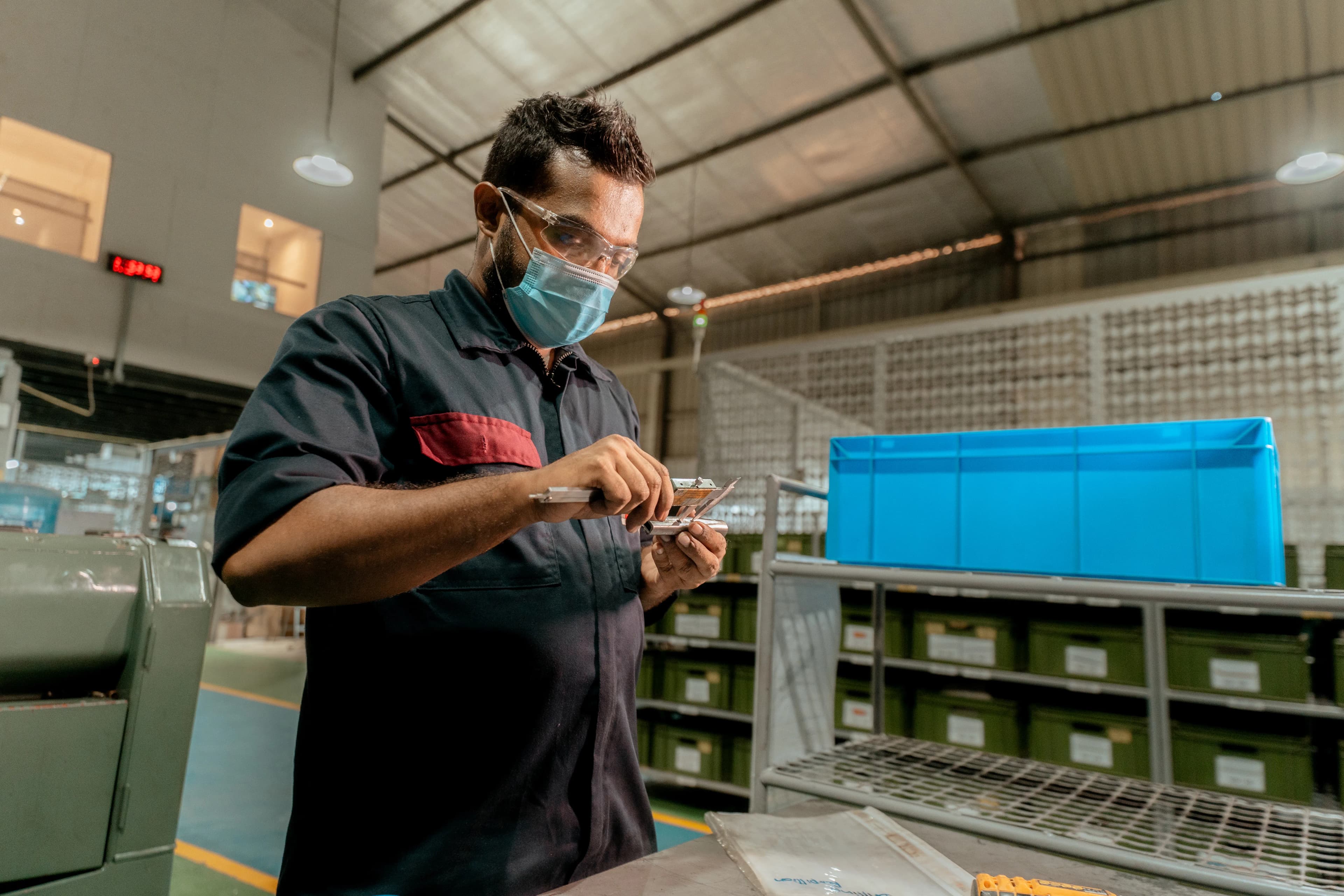 Engineer inspecting a machined metal component with a digital caliper